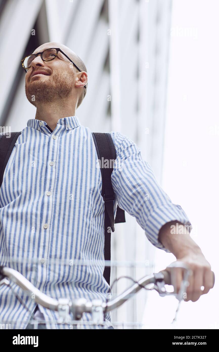 Low angle view of man standing with bicycle Stock Photo