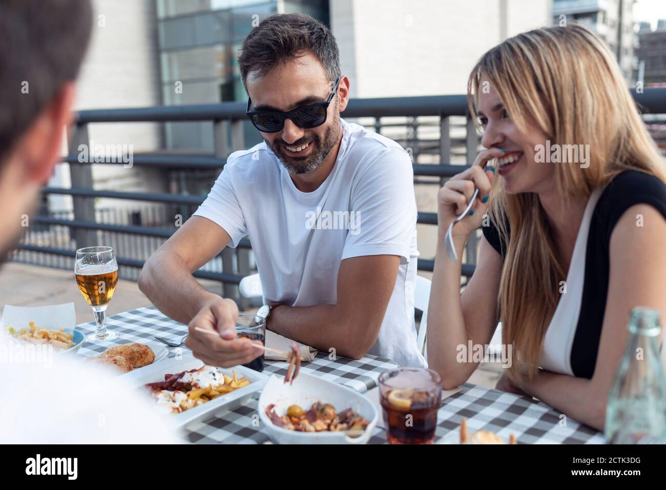 Smiling friends having meal while enjoying at restaurant Stock Photo