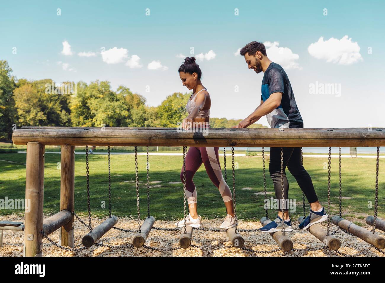 Man and woman walking on balance logs on a fitness trail Stock Photo