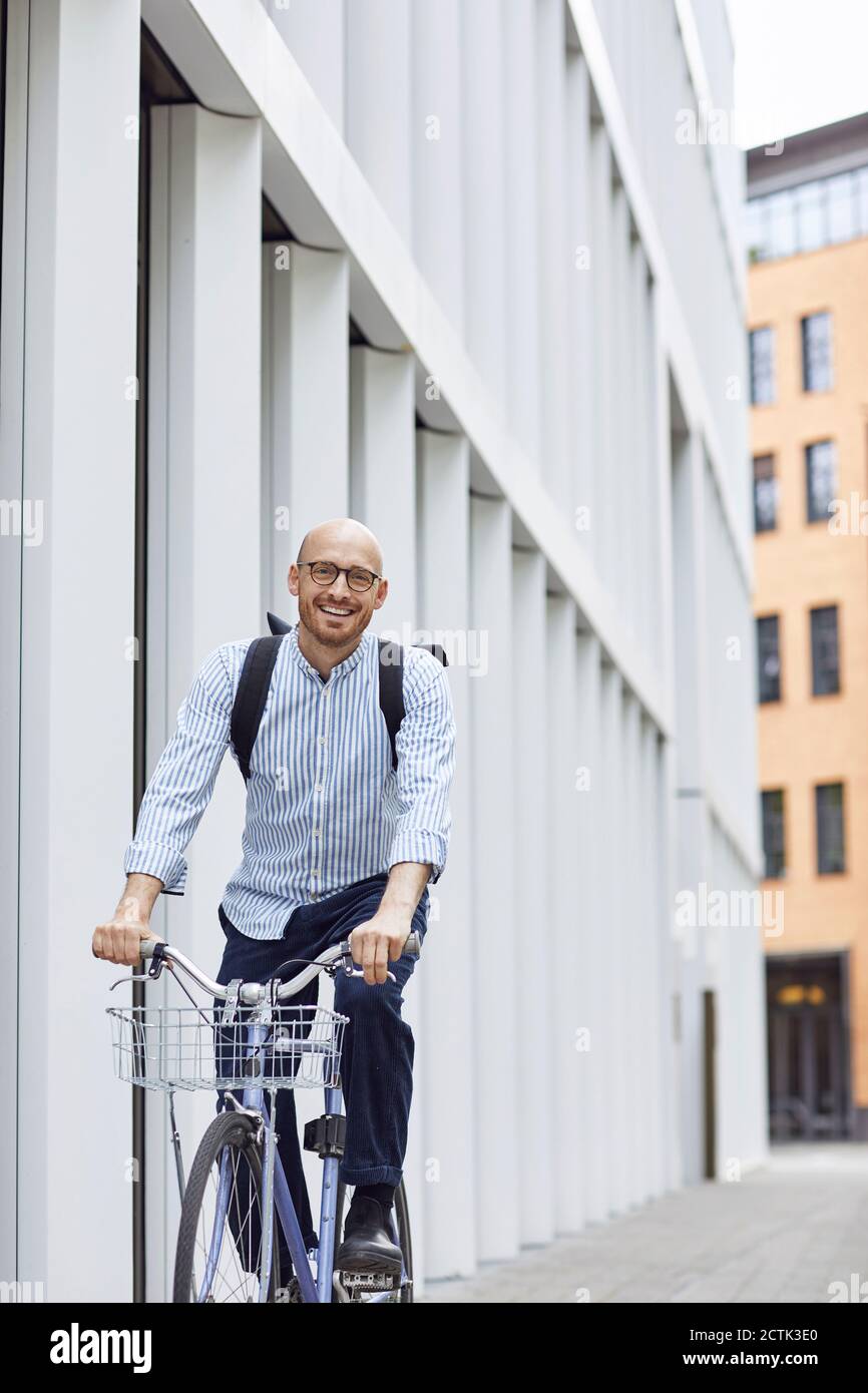 Happy man cycling bicycle on street in city Stock Photo