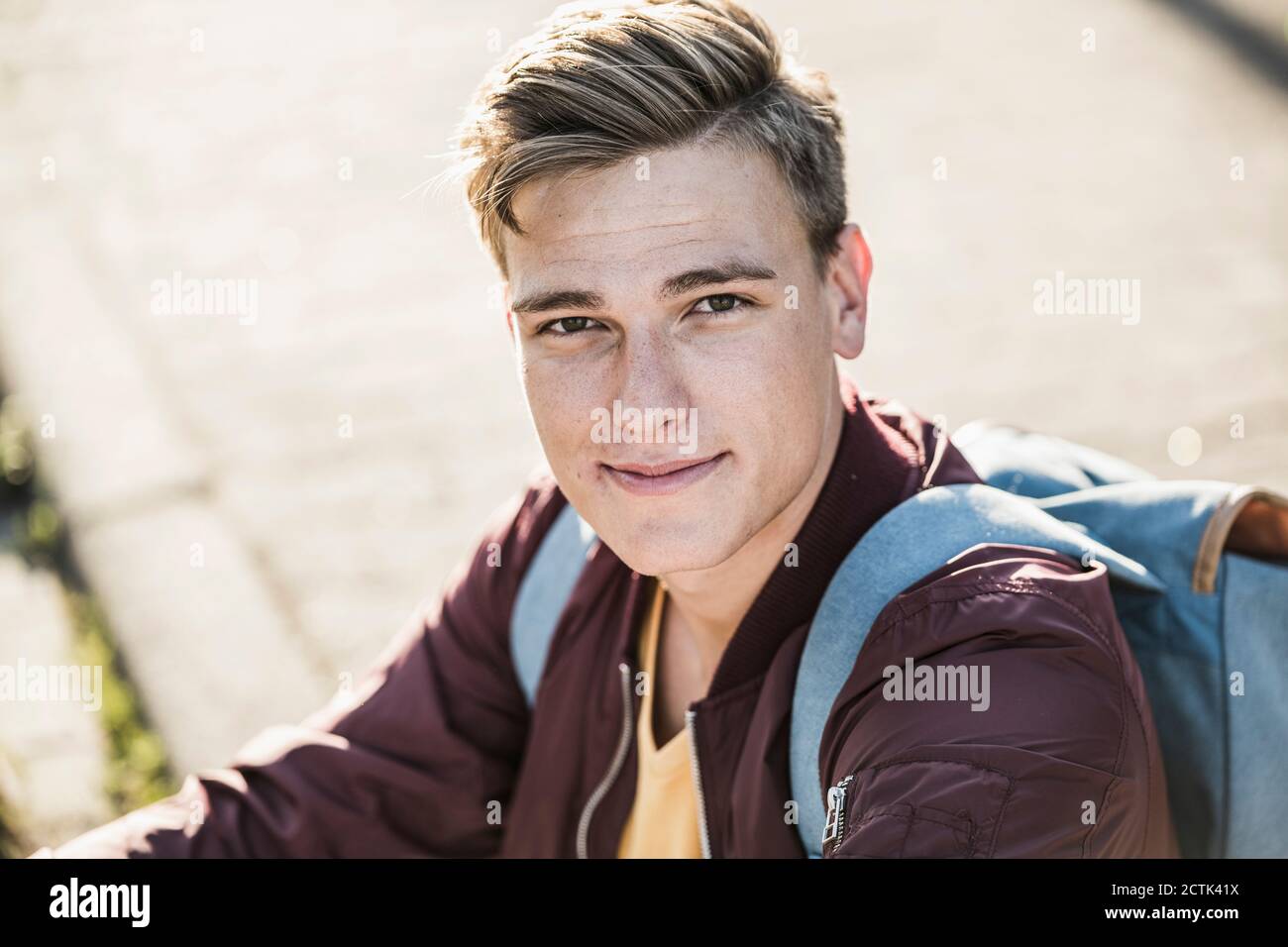 Handsome young man in casuals sitting outdoors Stock Photo