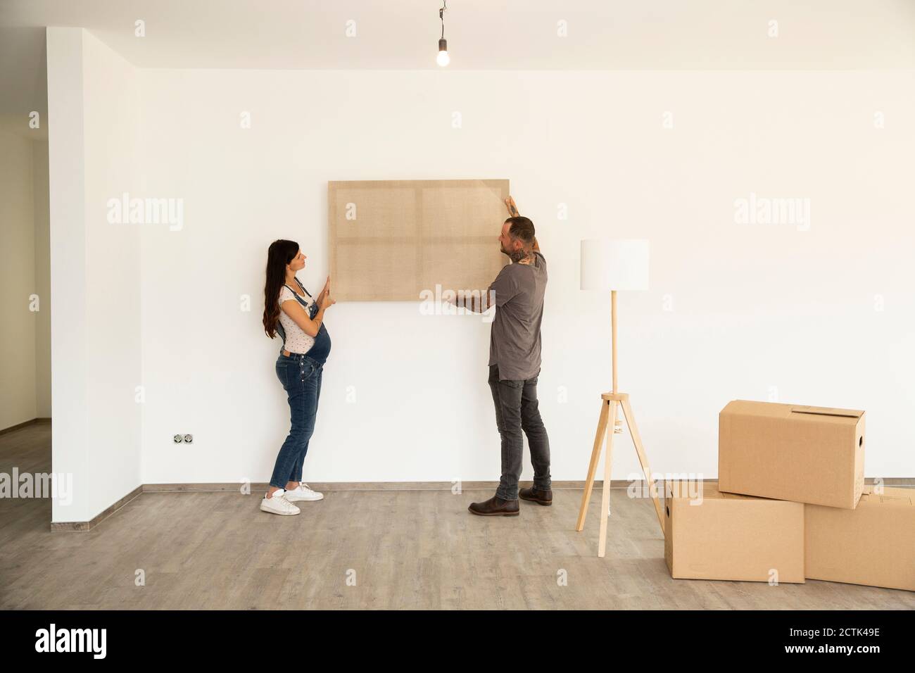 Couple carrying window frame while moving in new house Stock Photo