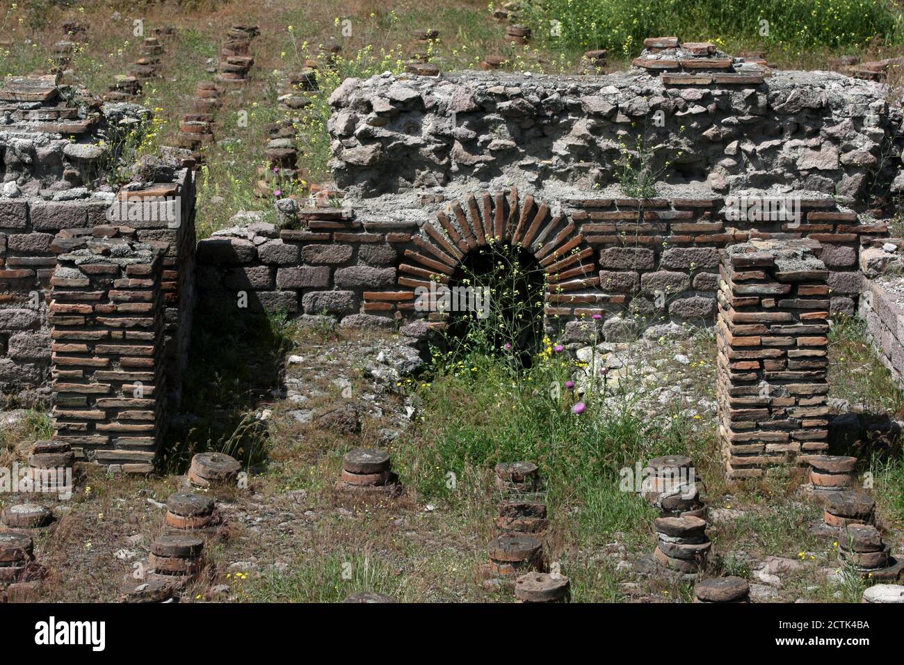 A section of the ancient Roman Bath ruins at Ankara in Turkey. The circular bricks formed the base for a subterranean subterranean heating system. Stock Photo