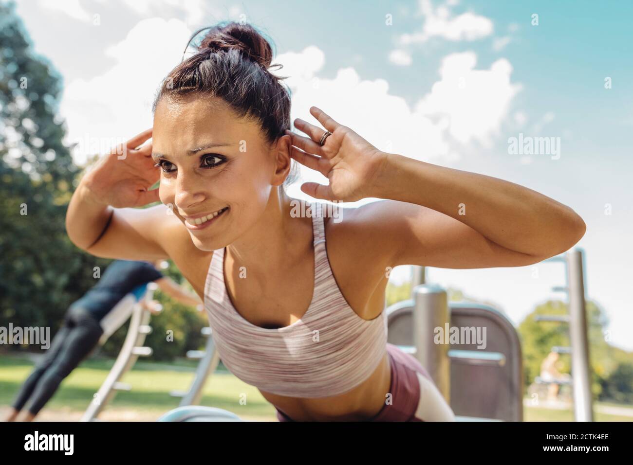 Portrait of wman doing push-ups on a fitness trail Stock Photo
