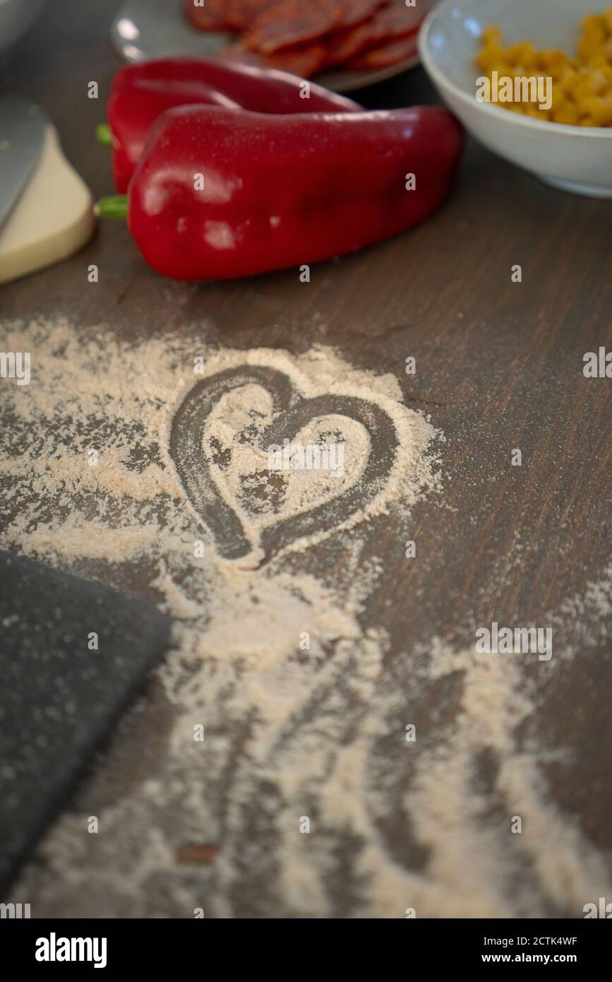 Heart shape drawn on flour over kitchen island Stock Photo