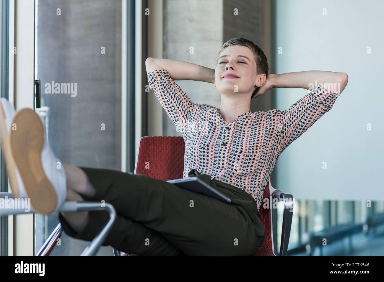 Relaxed businesswoman with closed eyes sitting on chair in office ...