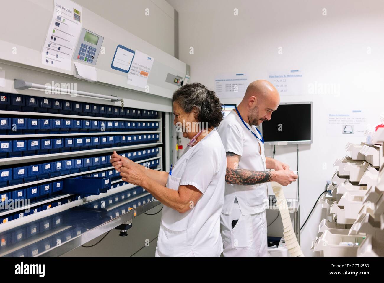 Male and female workers working in storage room at hospital Stock Photo