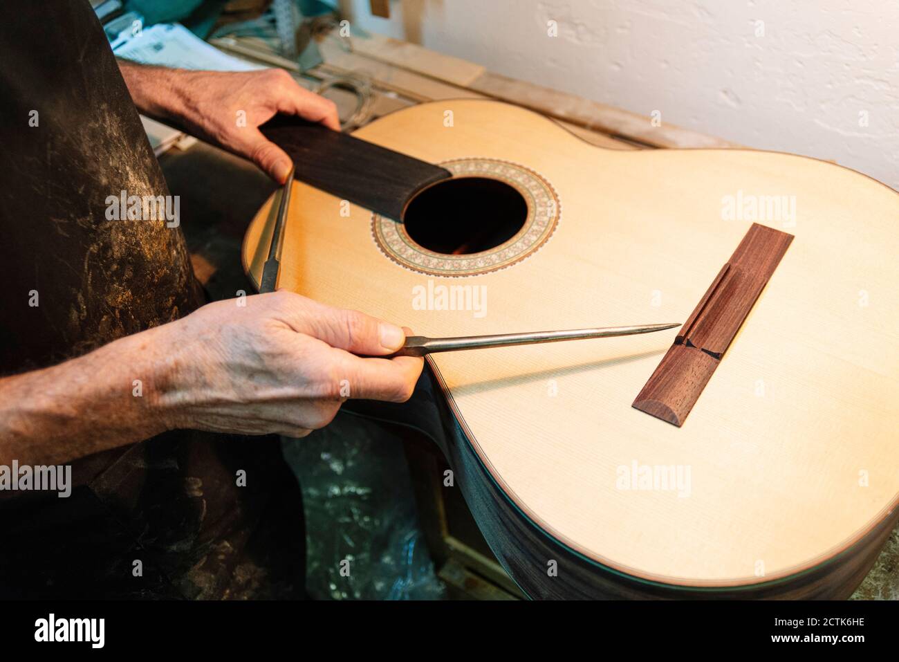 Instrument maker repairing guitar at workshop Stock Photo