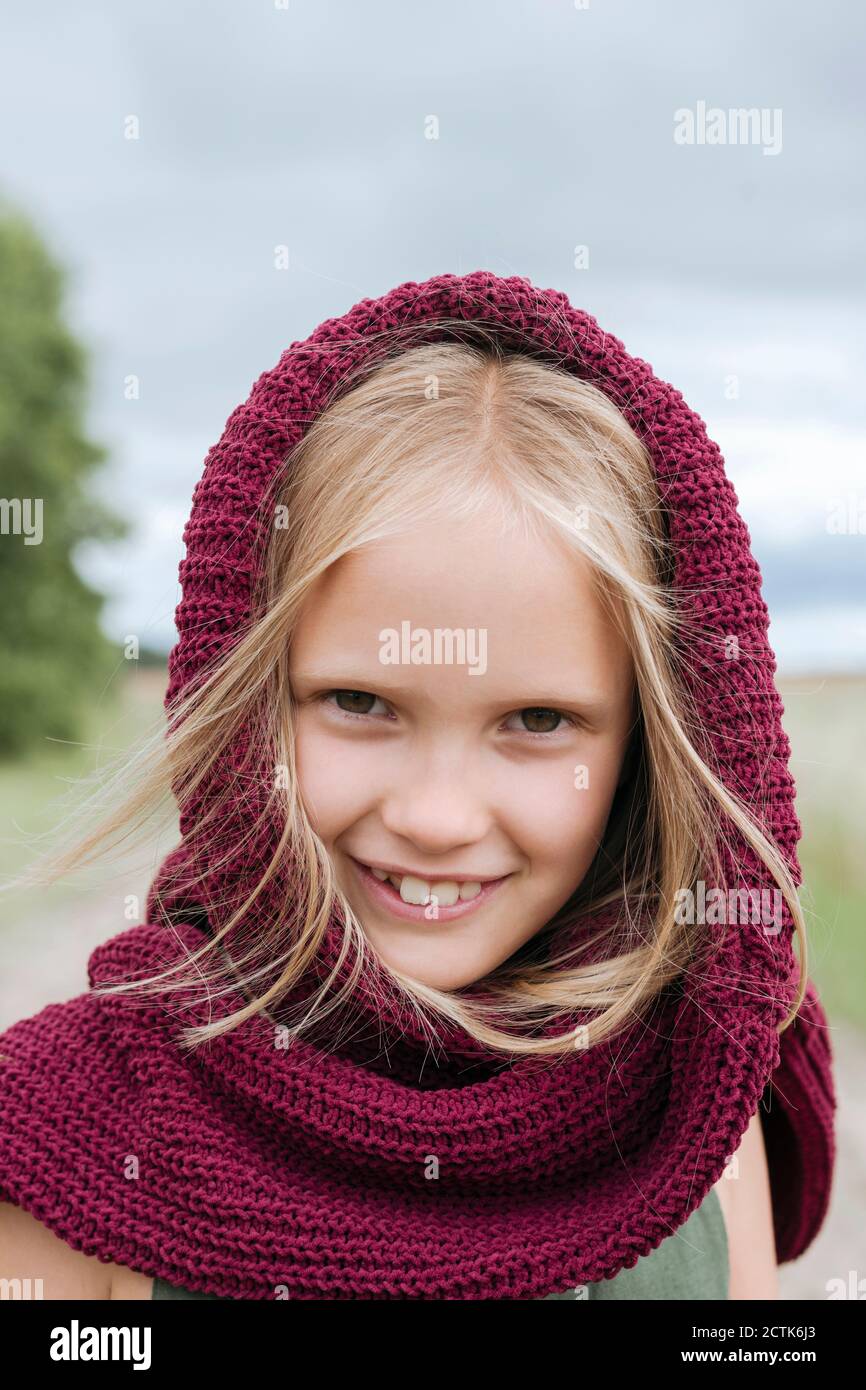 Portrait of smiling blond girl with round scarf Stock Photo - Alamy