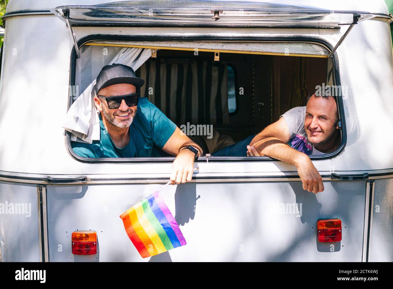 Smiling gay men sitting in motor home Stock Photo