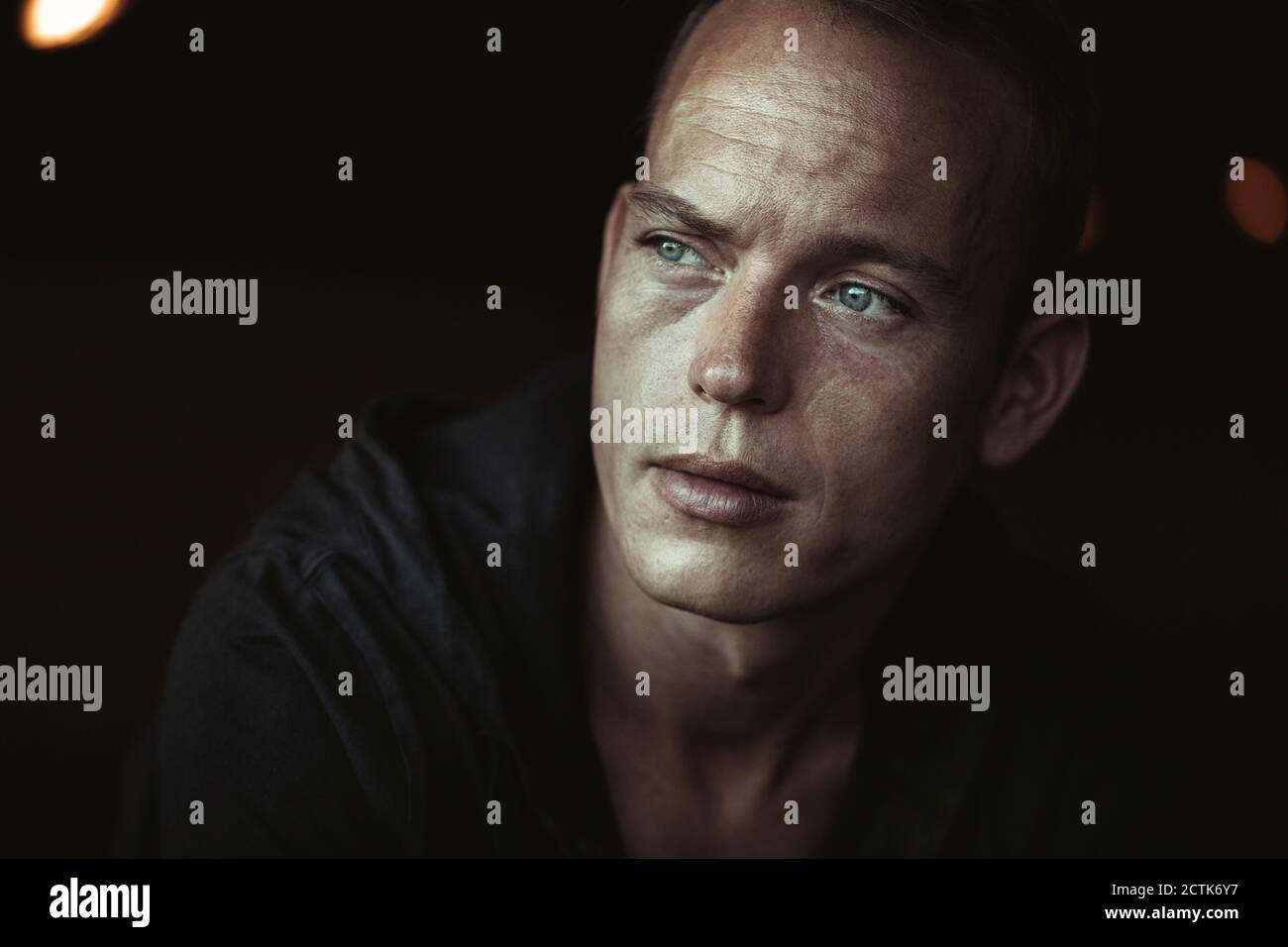 Close-up of man looking away in black tunnel Stock Photo