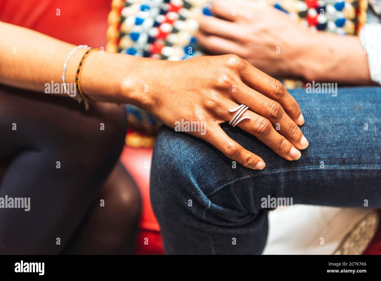 Close-up of woman hand on boyfriend's knee in cafe Stock Photo