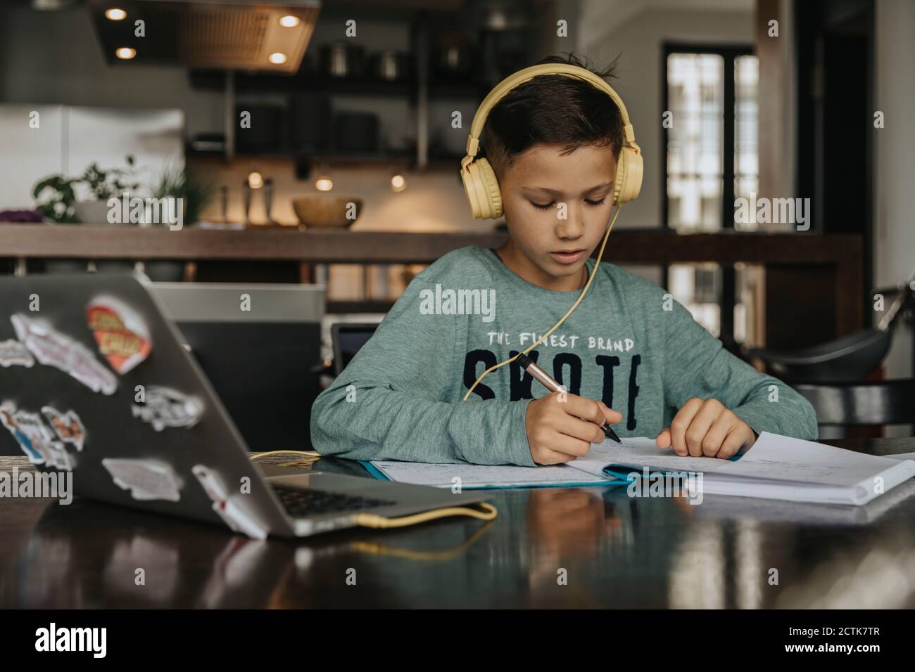 Schoolboy learning at home, using laptop and headphones Stock Photo - Alamy