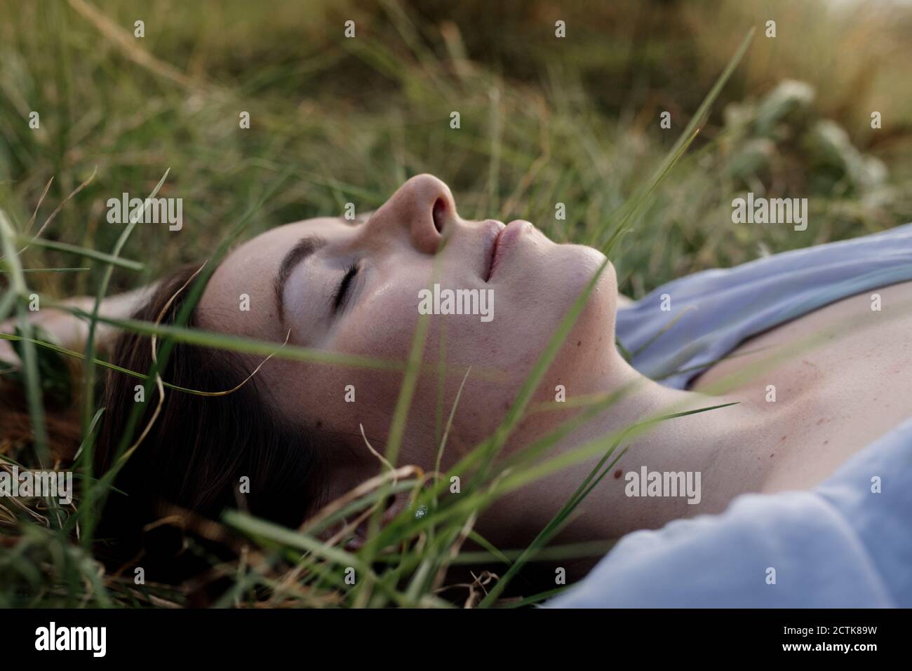 Beautiful woman relaxing with eyes closed on grass Stock Photo - Alamy
