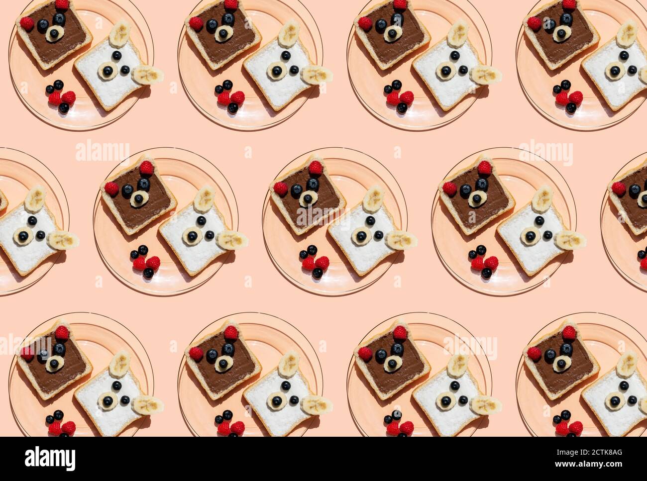 Pattern of plates with toasts decorated with bear faces made of fruits Stock Photo