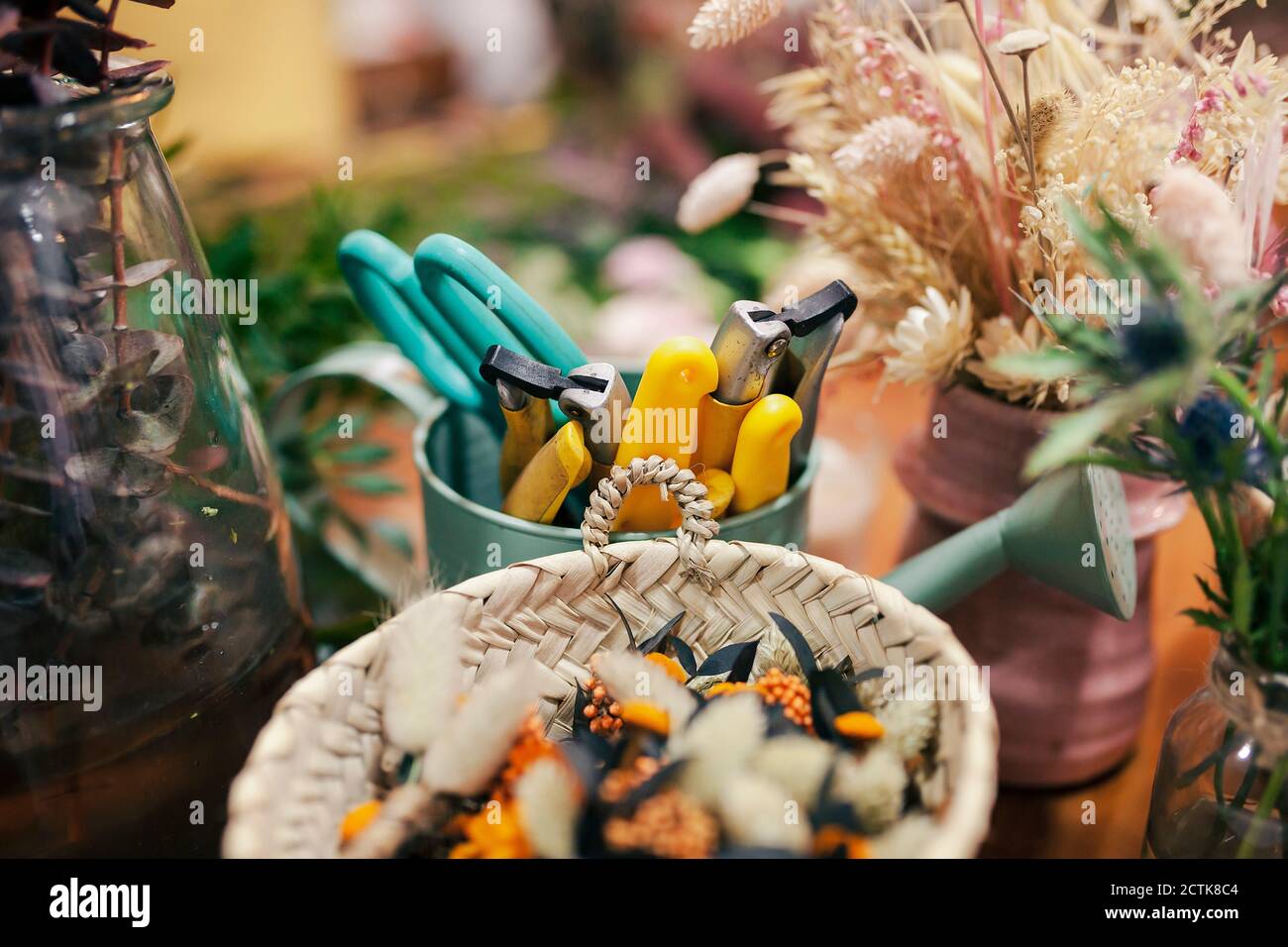 Gardening tool and flowers kept on table at flower shop Stock Photo