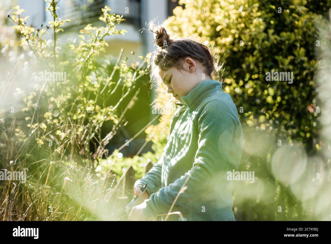 Girl with hand tool gardening in yard Stock Photo