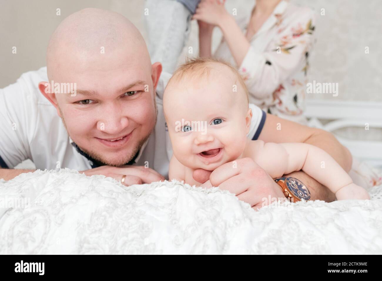 Smiling father with baby girl lying on bed Stock Photo - Alamy
