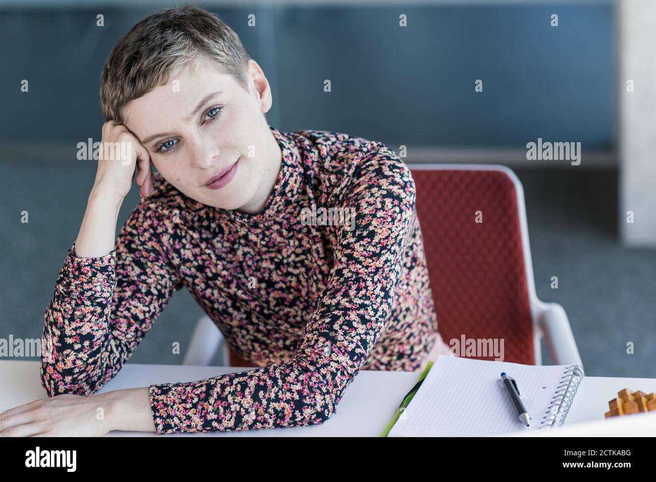 Portrait of a confident businesswoman leaning on desk in office Stock ...