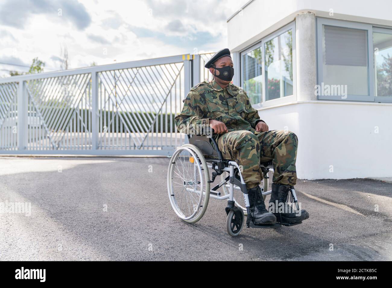Army soldier with protective face mask sitting on wheelchair Stock Photo