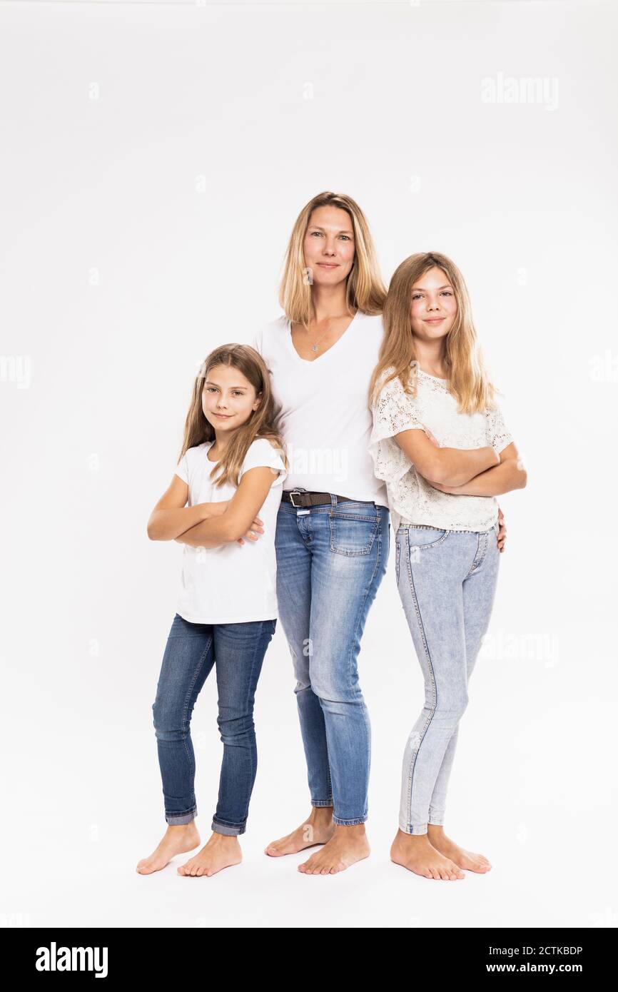 Mother with daughters standing against white background Stock Photo - Alamy