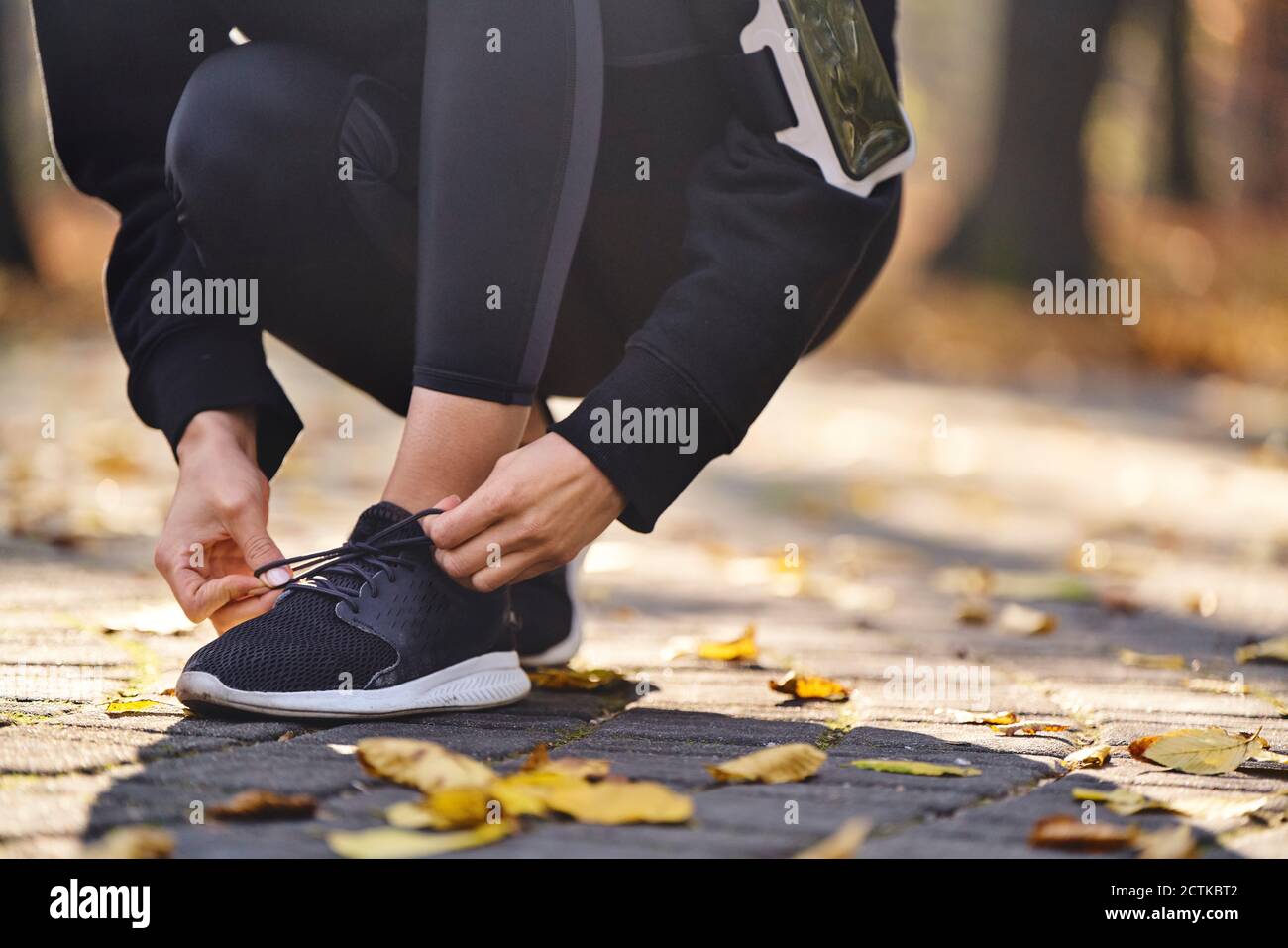 Young woman tying her running shoe Stock Photo