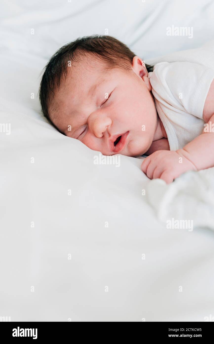 Cute newborn baby girl sleeping on bed in hospital Stock Photo