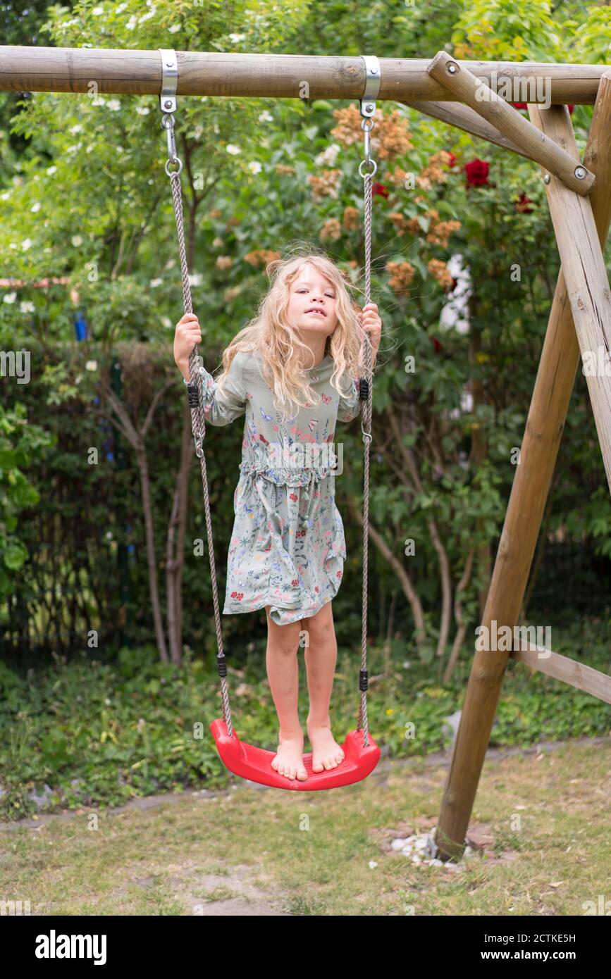 Boy and girl sharing swing on summer day in Sweden Stock Photo - Alamy