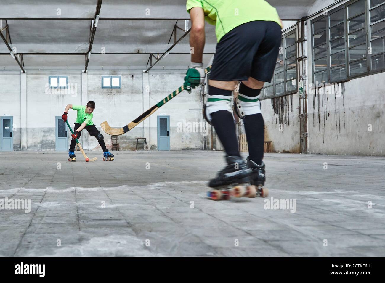 Father and son playing roller hockey on court Stock Photo Alamy