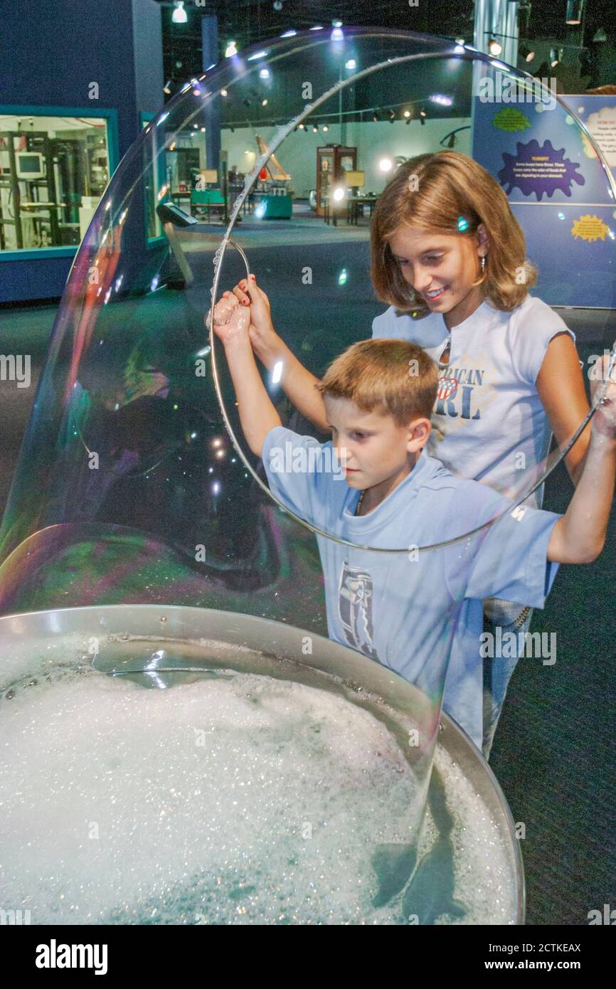 Huntsville Alabama,Sci-Quest Hands-on Science Center,inside interior,boy girl brother sister siblings making giant soap bubble bubbles Stock Photo