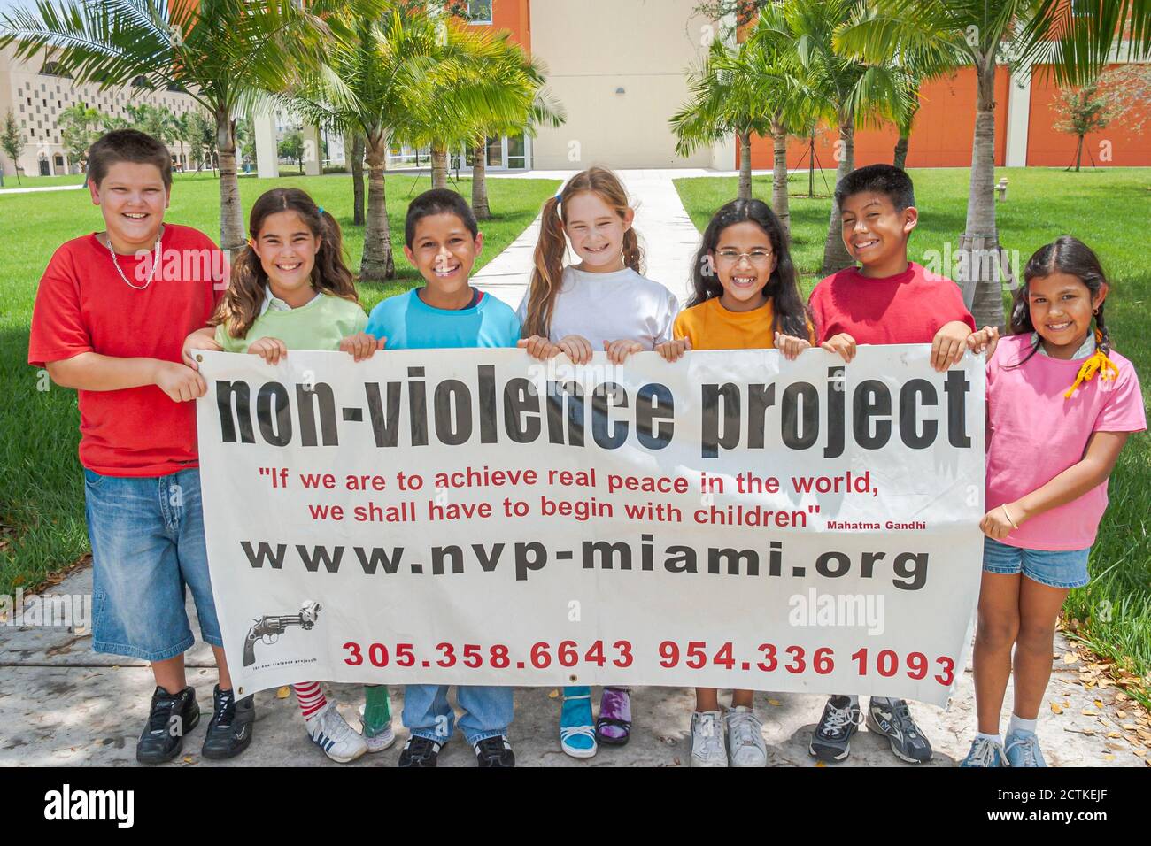 Miami Florida,Non Violence Project USA,teaching student students non violent behavior,boys boy girl girlss smiles smiling,hold holding banner,Hispanic Stock Photo