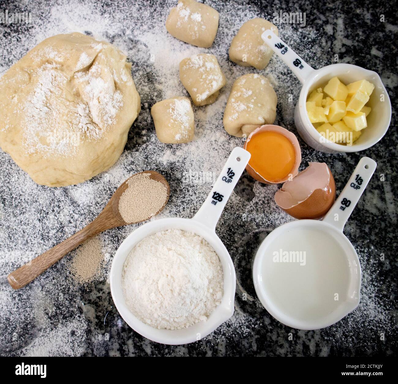 Making bread rolls background. Flour, egg, butter on granite. Selective focus. Stock Photo