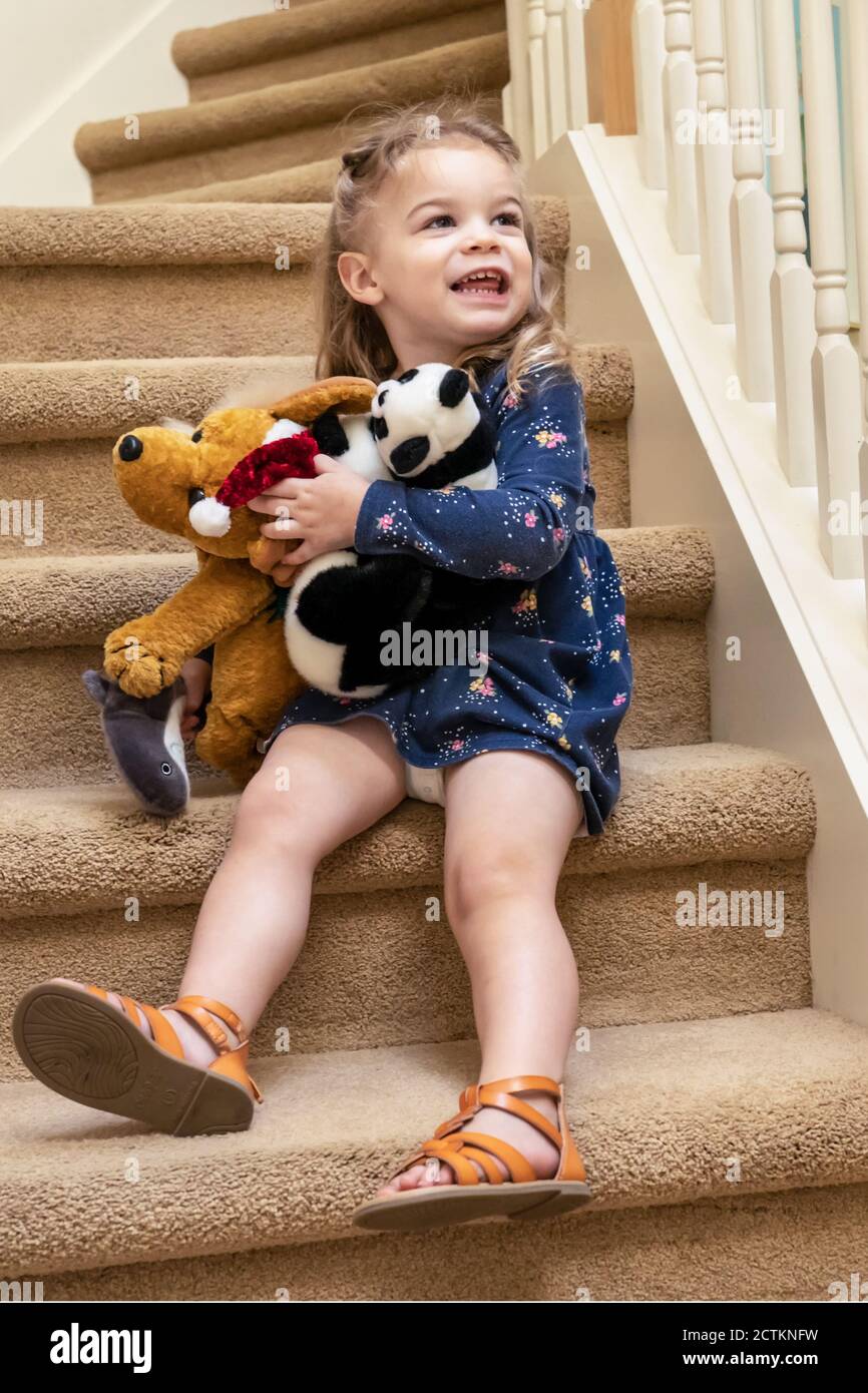 2.5 year old girl playing with stuffed animals on the stairway