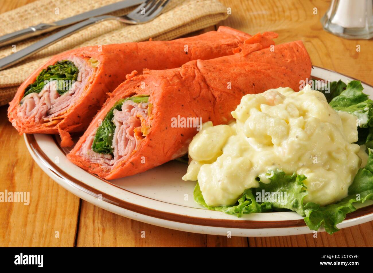 Wrap sandwich with ham, pepperoni, salami and romaine lettuce Stock