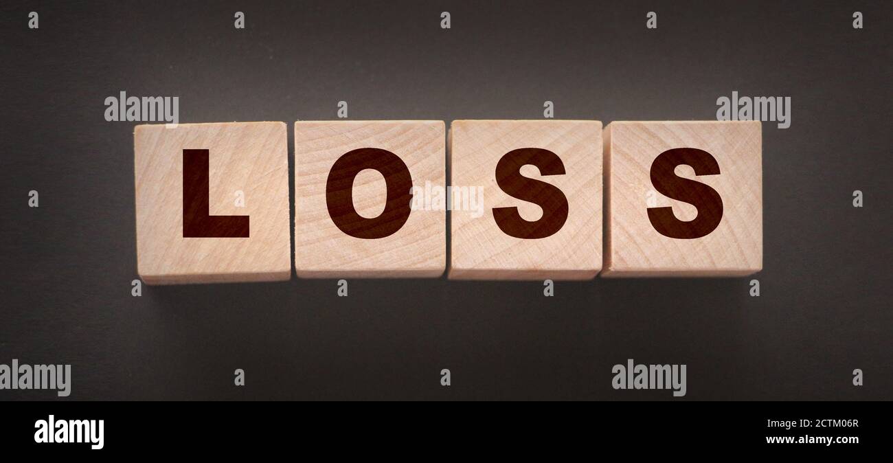 Wooden cubes with LOSS word on blacktable. Financial loss busines concept Stock Photo