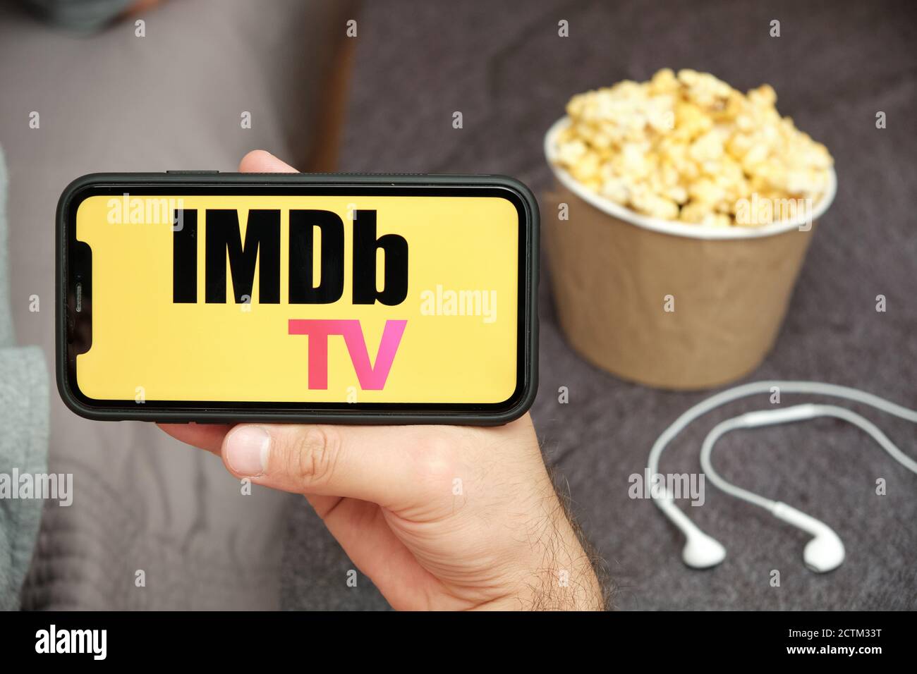 IMDb TV logo on the mobile phone screen with popcorn box and Apple earpods  on the background. Leisure time at home concept. September 2020, San Stock  Photo - Alamy