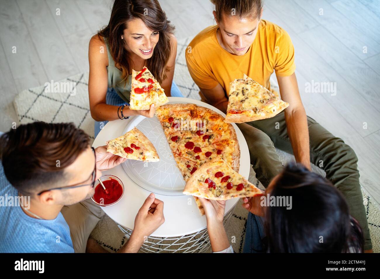 Young friends eating pizza at home on winter reunion - Friendship concept  with happy people enjoying time together and having fun drinking brew pints  Stock Photo - Alamy