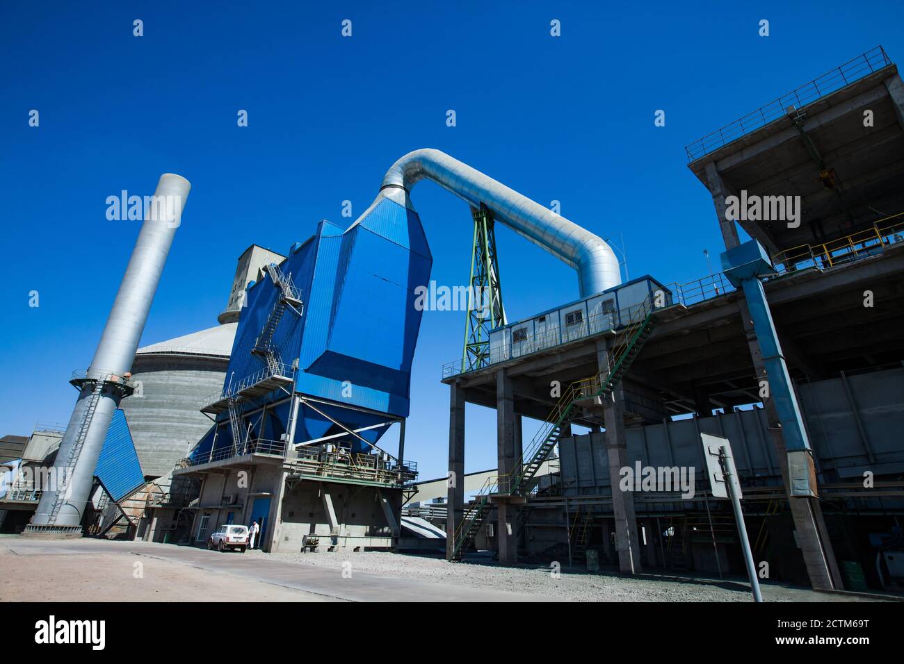 Mynaral/Kazakhstan - April 23 2012: Modern Jambyl Cement plant. Hopper, silo and plant chimney on blue sky. Panorama view. Stock Photo