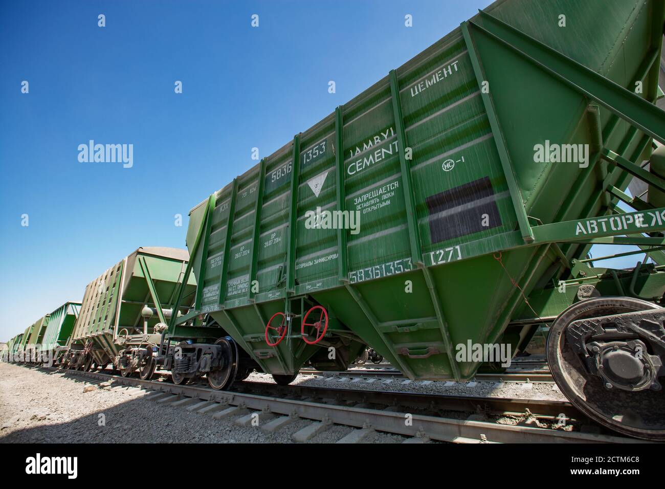 Mynaral/Kazakhstan - April 23 2012: Modern cement plant in desert. Cargo train loading railroad terminal. Wide-angle lens. Stock Photo