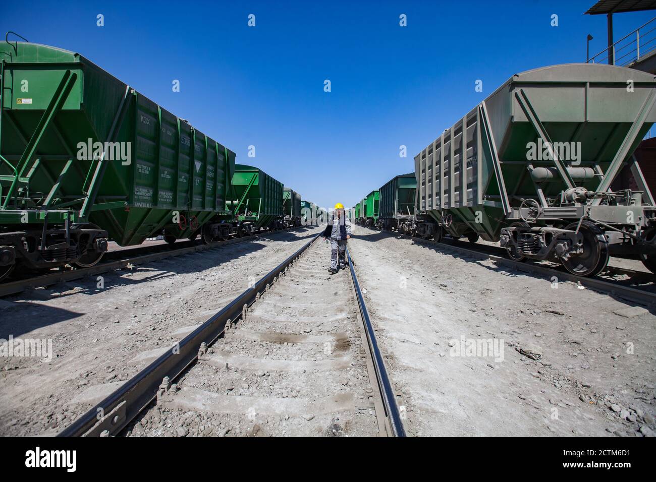 Mynaral/Kazakhstan - April 23 2012: Cargo railroad terminal. Worker in yellow hardhat. Stock Photo