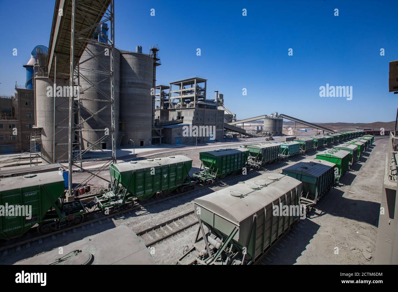 Mynaral/Kazakhstan - April 23 2012: Modern cement plant in desert. Cargo railroad terminal. Cement silo. Blue sky background. Stock Photo