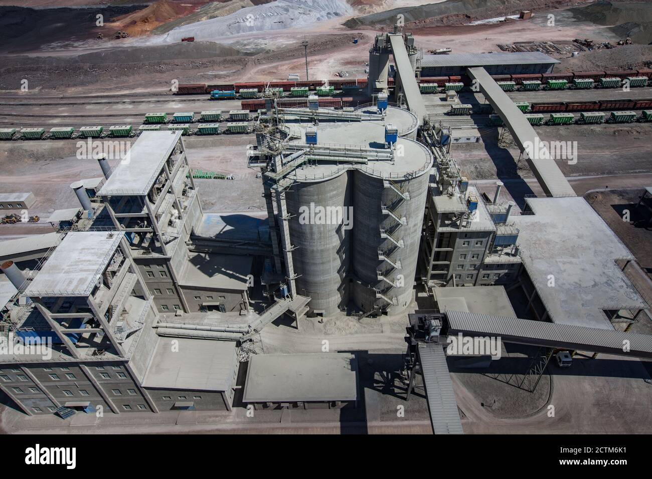 Mynaral/Kazakhstan - April 23 2012: Jambyl Cement plant. Aerial view on railway cargo terminal with train and cement silos and pile of clinker mineral Stock Photo