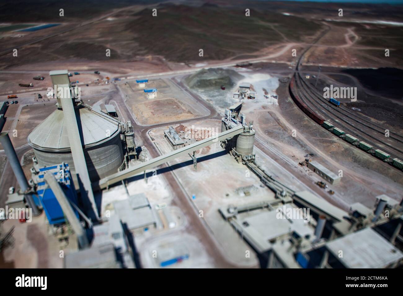 Mynaral/Kazakhstan - April 23 2012: Jambyl Cement plant. Aerial view on concrete silo and conveyor and railroad. Tilt-shifted blurred photo. Stock Photo