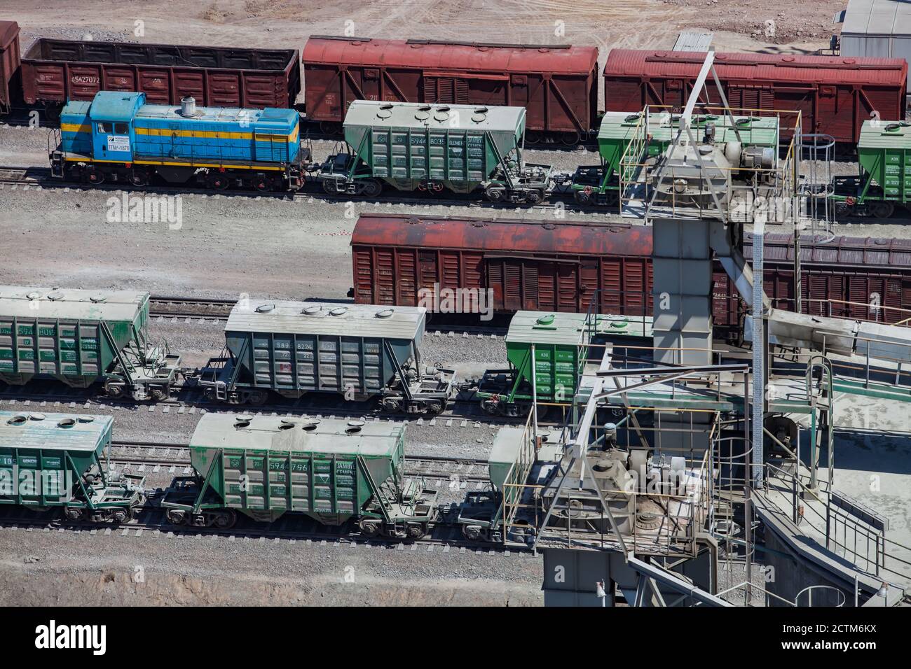 Mynaral/Kazakhstan - April 23 2012: Cargo railroad terminal of Modern cement plant in desert. Railway carriages and locomotive. Stock Photo