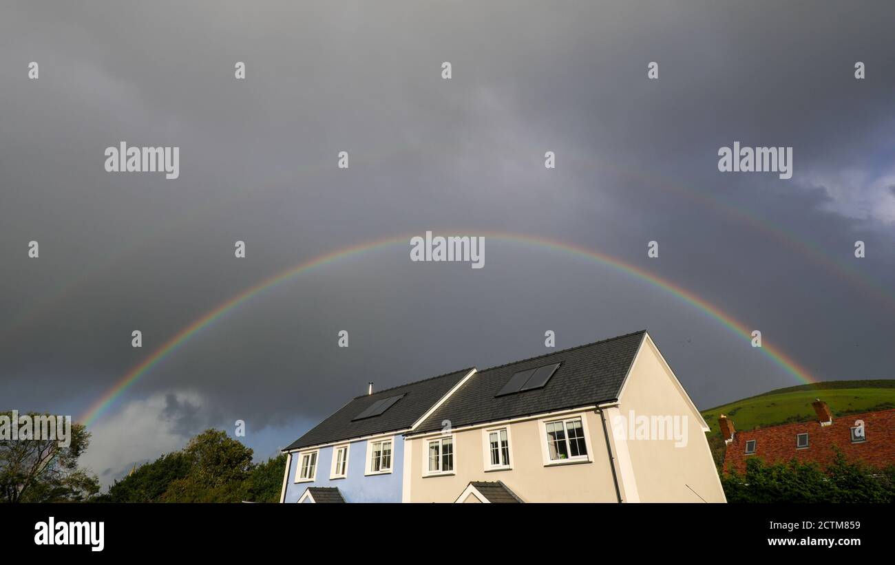 Llanrhystud, Ceredigion, Wales, UK. 24th September 2020 UK Weather: Sunshine and showers, with a bright rainbow above the village of Llanrhystud in mid Wales. © Ian Jones/Alamy Live News Stock Photo