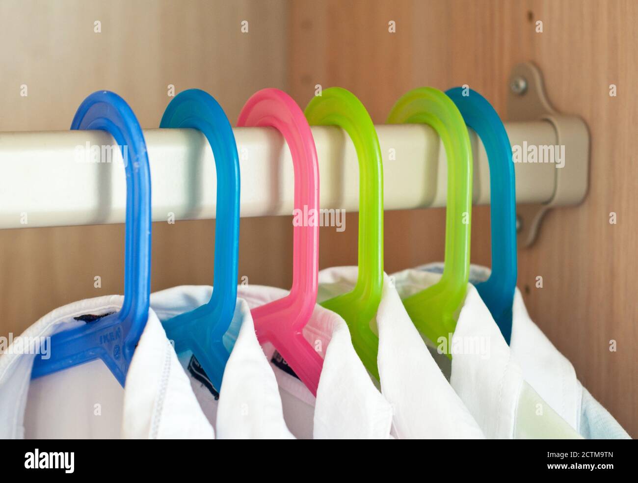 White shirts hang in the closet on hangers Stock Photo