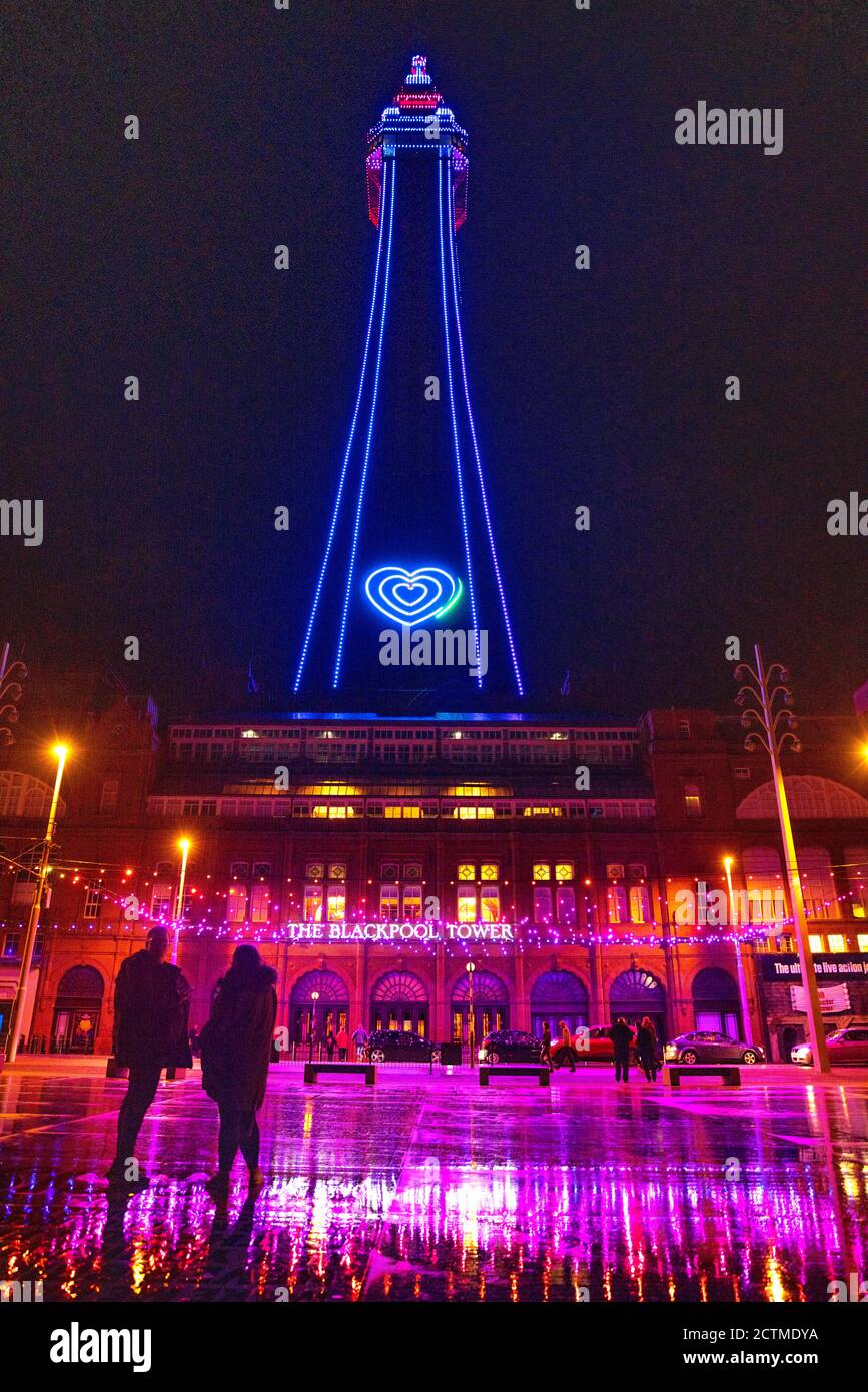 A couple stop on the comedy floor in front of Blackpool Tower during the illuminations. All pubs, bars, restaurants in England must have a 10pm closing time from Thursday, to help curb the spread of coronavirus. Stock Photo