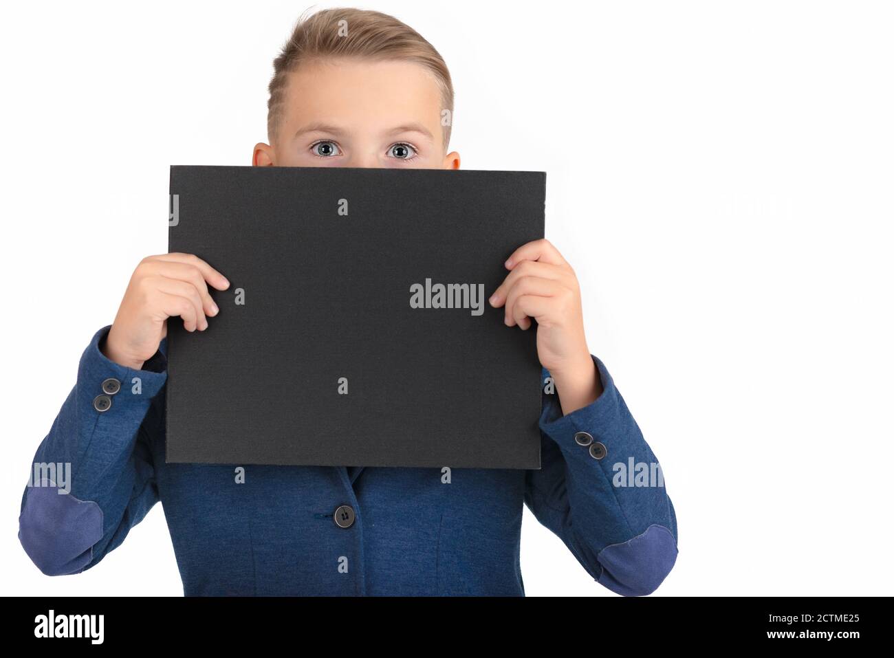 The caucasian boy covers himself with a black blank poster, only eyes are visible. boy showing