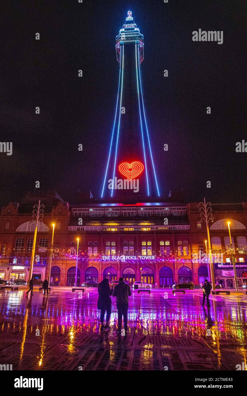 A couple stop on the comedy floor in front of Blackpool Tower during the illuminations. All pubs, bars, restaurants in England must have a 10pm closing time from Thursday, to help curb the spread of coronavirus. Stock Photo