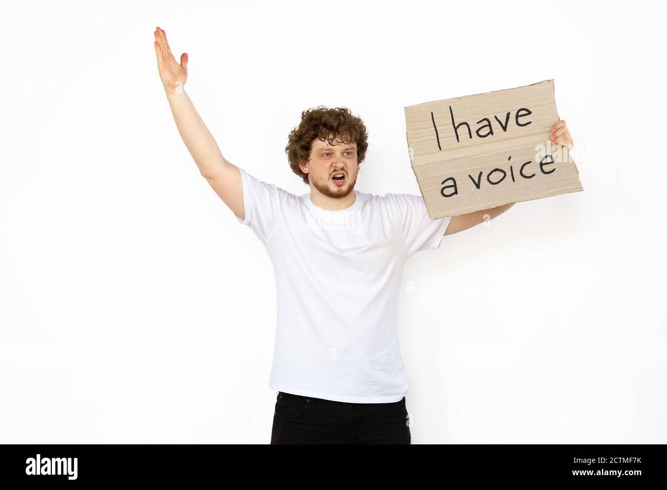 I have a voice. Young man protesting with sign isolated on white studio background. Activism, active social position, protest, actual problems. Meeting against human rights, politics, freedom of choice. Stock Photo